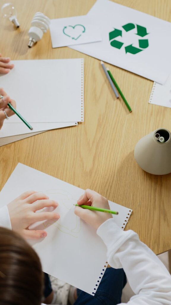 Kids drawing eco-friendly symbols, promoting recycling and sustainability.